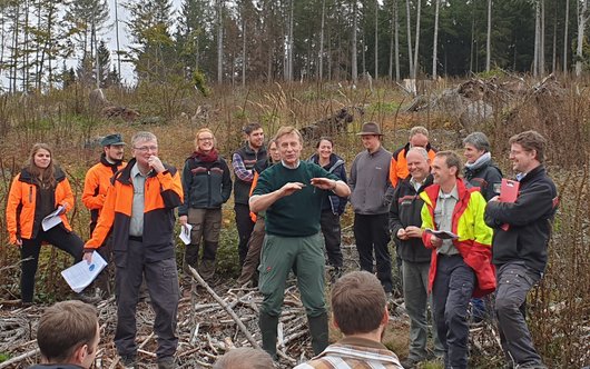 Forstleute bei einem Vortrag im Wald